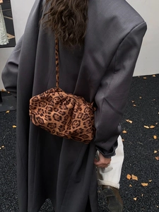 Street style shot of a leopard print ruched hobo bag paired with a grey blazer
