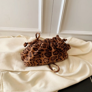 Close-up of leopard print drawstring handbag with textured surface and soft rope details