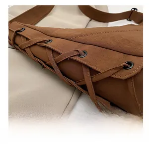 Detailed macro view of the drawstring design and fabric texture on a brown shoulder bag