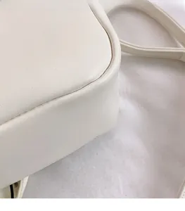 Close-up of beige leather mini crossbody bag showing premium stitching and smooth texture