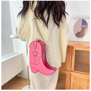 Détail du sac à bandoulière rose en forme de botte de cowboy avec étoiles et chaîne argent