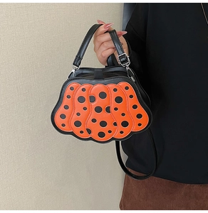 Dettaglio della borsa a mano a forma di zucca con pois arancioni e neri vivaci