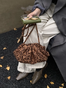 Detailed view of leopard print ruched cloud bag with soft texture and slim shoulder strap