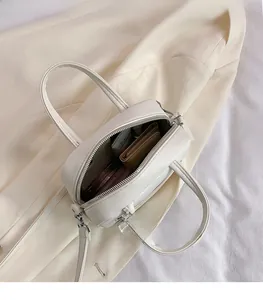 Detail view of the spacious inner compartment and zipper of the cream PU leather mini bag