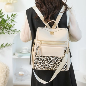 Detail of leopard print patchwork on beige backpack with tassel zipper and webbed strap