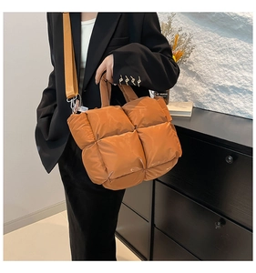 Sac fourre-tout matelassé caramel avec large bandoulière dans un décor intérieur