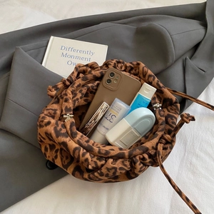 Detailed view of leopard print suede bucket bag showing spacious interior for essentials