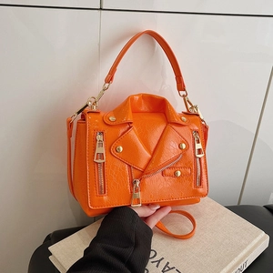 Bright orange biker jacket style crossbody bag with metal zippers and studs on white background