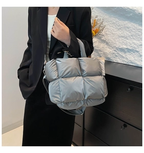 Détail d'un sac à main matelassé gris argenté avec texture en nylon mat et bandoulière