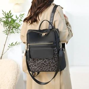 Detail of leopard print backpack worn by model in a stylish Nordic indoor setting