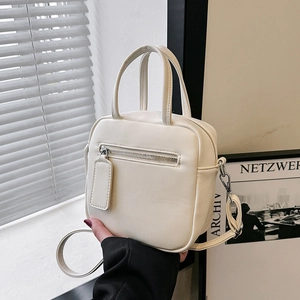 Chic beige minimalist crossbody square bag with silver zipper and natural lighting scene