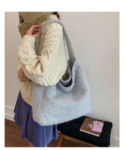 Detail of light blue plush tote bag styled with casual winter outfit and knit sweater