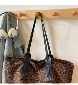 Close-up of leopard print tote bag with durable black handles hanging on a wall hook