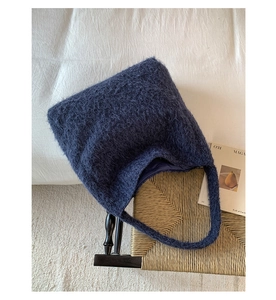 Macro view of shaggy navy blue plush fabric texture and spacious interior of the tote bag