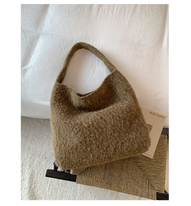 Detail of soft brown faux fur hobo bag showing its plush texture and knitted strap
