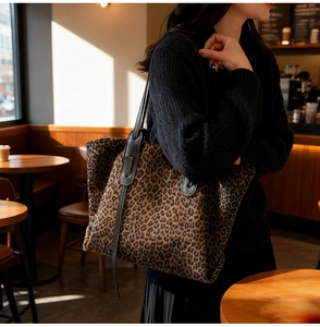 Close-up of leopard print tote bag in cafe setting showing its texture and capacity