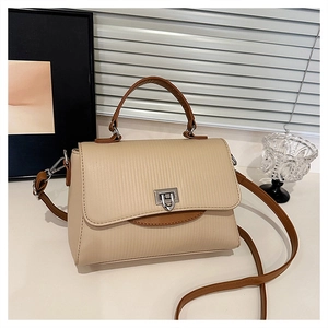 Detail of beige tote bag showing vertical stripe texture and silver square lock