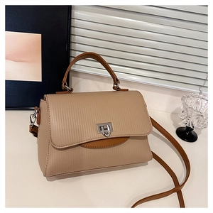 Detail of khaki crossbody bag with vertical textures and bright silver swivel clasp