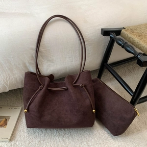 Chocolate brown suede tote set with drawstring and gold accents in a home setting
