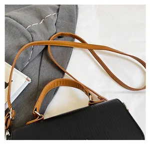 Detail shot of the textured black leather shoulder bag with durable brown shoulder straps
