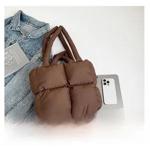Detail view of the quilted dark brown tote bag with puffy padded texture and thick handles
