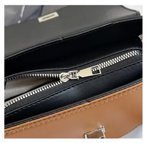 Detail of smooth metal zipper and premium leather stitching on the contrast handbag