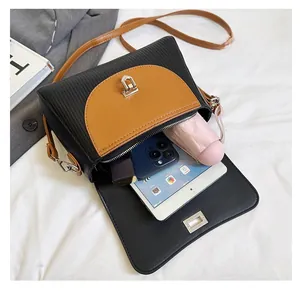 Detail view of large capacity crossbody bag interior holding phone and umbrella