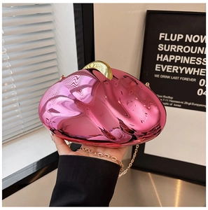 Detail of metallic pink irregular acrylic clutch with gold clasp and chain strap