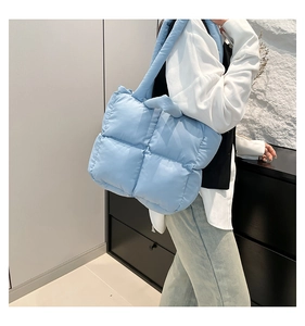 Close-up of light blue quilted tote bag showing the soft padded texture and stitching