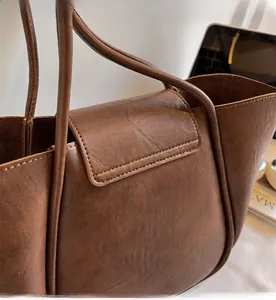 Close-up of vintage brown leather tote bag showing fine stitching and premium texture