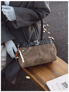 Detail of vintage patchwork tote bag with denim-style stitching and wood bead charm