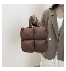 Close-up of a brown quilted tote bag with soft padded texture and top handles