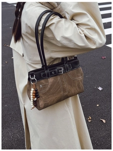 Detail of vintage patchwork shoulder bag with brown suede, black leather and bead charms