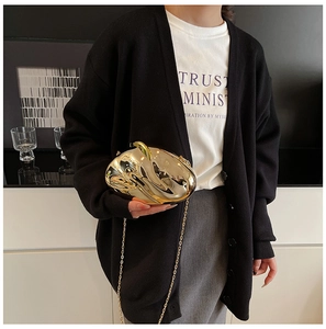 Detail of trendy gold mirror acrylic evening clutch with chic metal chain for women