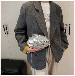 Close-up of a futuristic silver mirror clutch bag with an irregular liquid-metal shape
