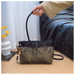 Close-up of vintage canvas shoulder bag with leather straps and decorative beads
