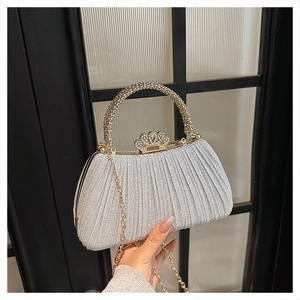 Detail of silver sequined evening bag with rhinestone handle and crown clasp