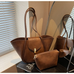 Detail of vintage brown leather tote bag set with buckle and matching small zipper pouch