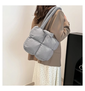 Detailed side view of the grey quilted tote bag showing its textured cloud fabric finish