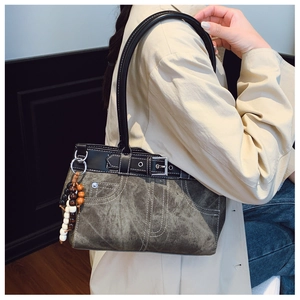 Detail view of vintage canvas shoulder bag with denim pocket stitching and wooden beads