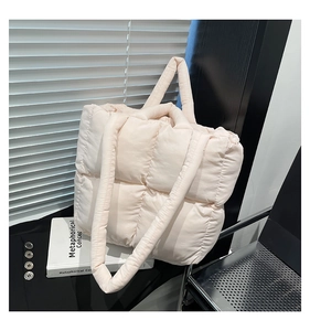 Detailed view of cream quilted tote bag with soft padded texture and top handles