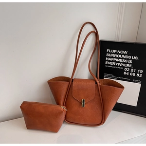 Detail view of caramel brown tote bag with metal clasp and matching small pouch set