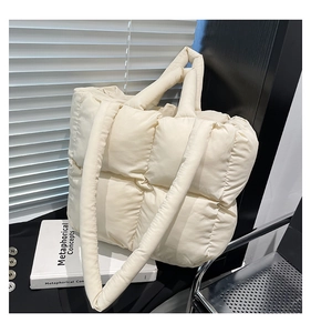 Close-up of beige quilted tote bag showing soft nylon texture and large grid pattern