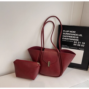 Detail of burgundy faux leather tote with matching zipper pouch and gold buckle clasp