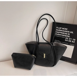 Detail of black faux leather tote set with small zipper pouch and gold metal clasp hardware