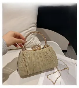 Detailed macro of champagne gold evening clutch with sequins and beaded ring handle