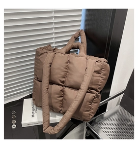 Detailed view of brown quilted puffer tote bag with puffy square stitch and nylon texture