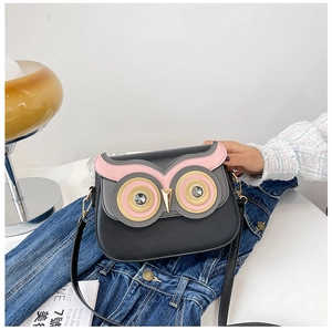 Détail du sac bandoulière hibou avec yeux en cristal sur fond de style vintage