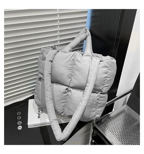 Detail of light grey quilted tote bag with soft padded texture in a modern setting