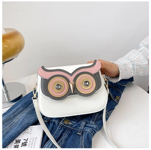 Détail macro d'un sac bandoulière hibou blanc avec des yeux en strass étincelants